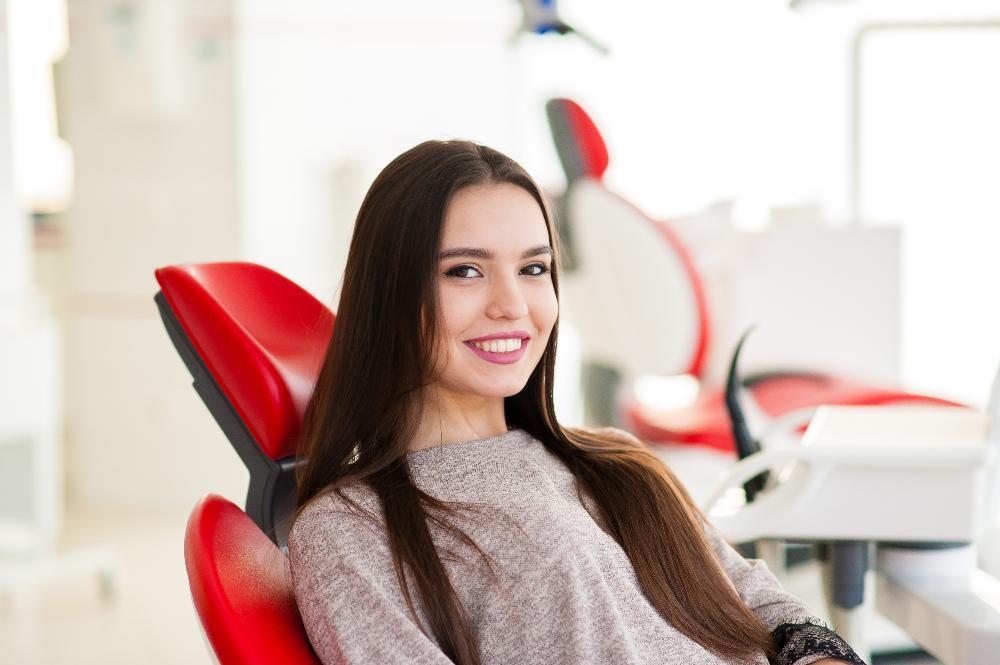 woman sitting in dental exam chair | emergency dentist fairfax va